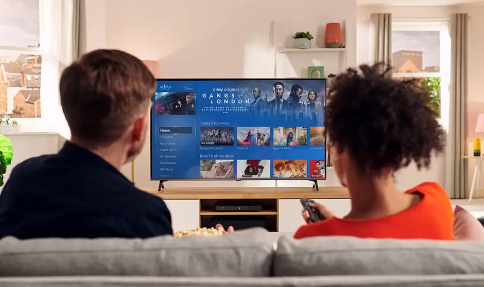 Familie beim gemeinsamen Filmabend vor einem großen Fernseher
