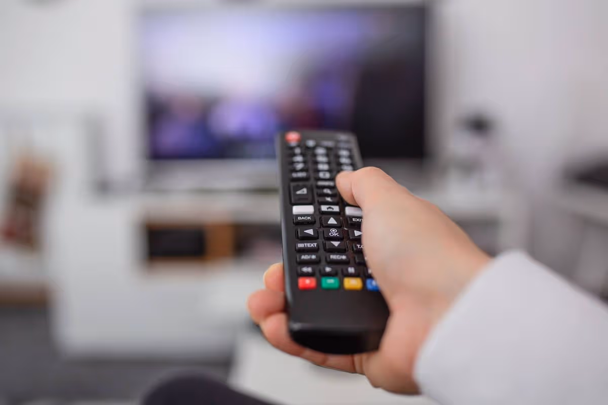 Moderne Fernbedienung für eine Streaming-Box in der Hand